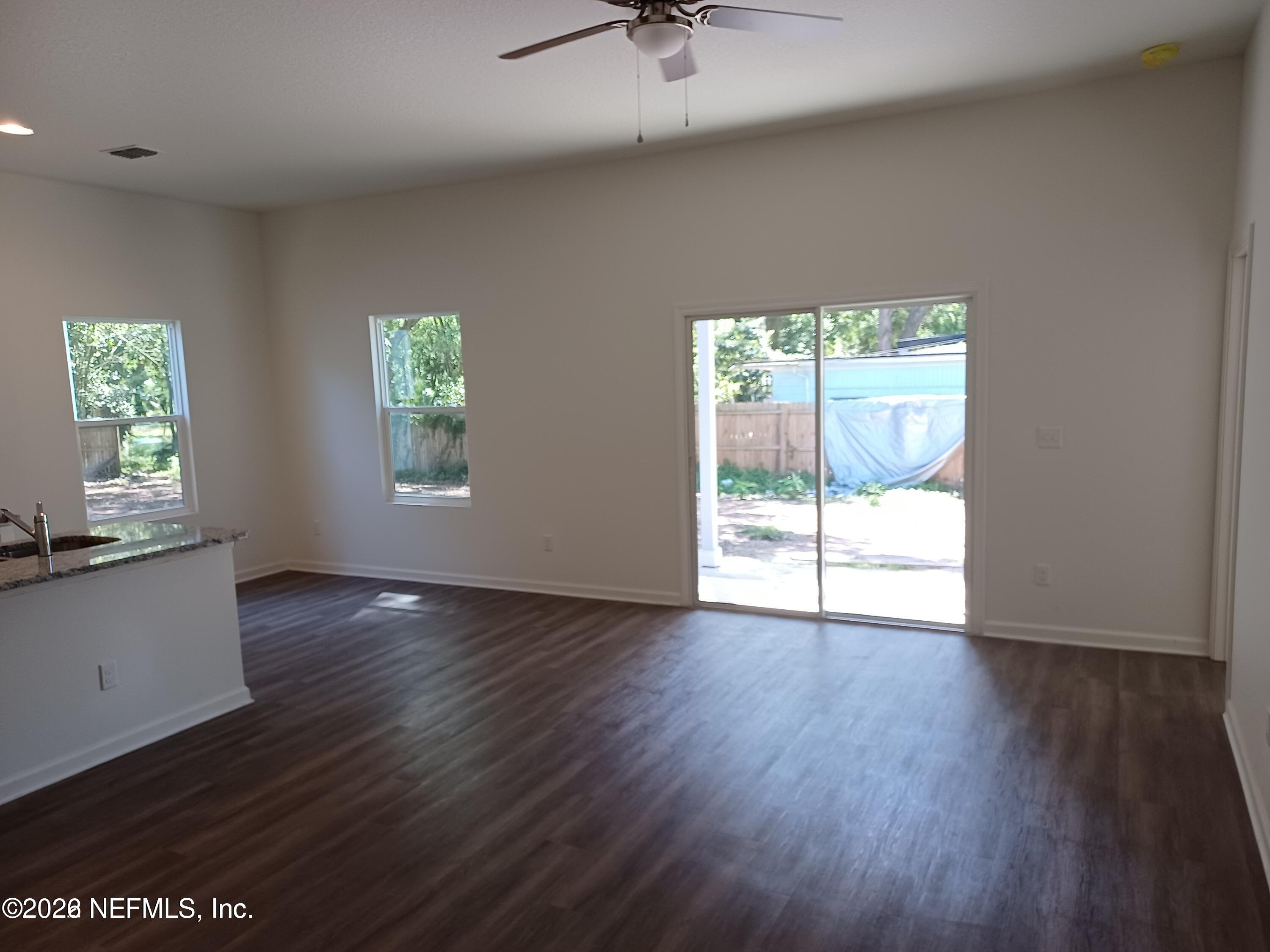3006 Alonso Road Jacksonville, FL 32216 - Photo 2 of 16 an empty room with wooden floor and windows