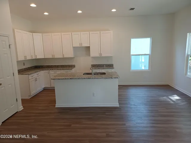 a kitchen with stainless steel appliances granite countertop a white stove top oven and white cabinets