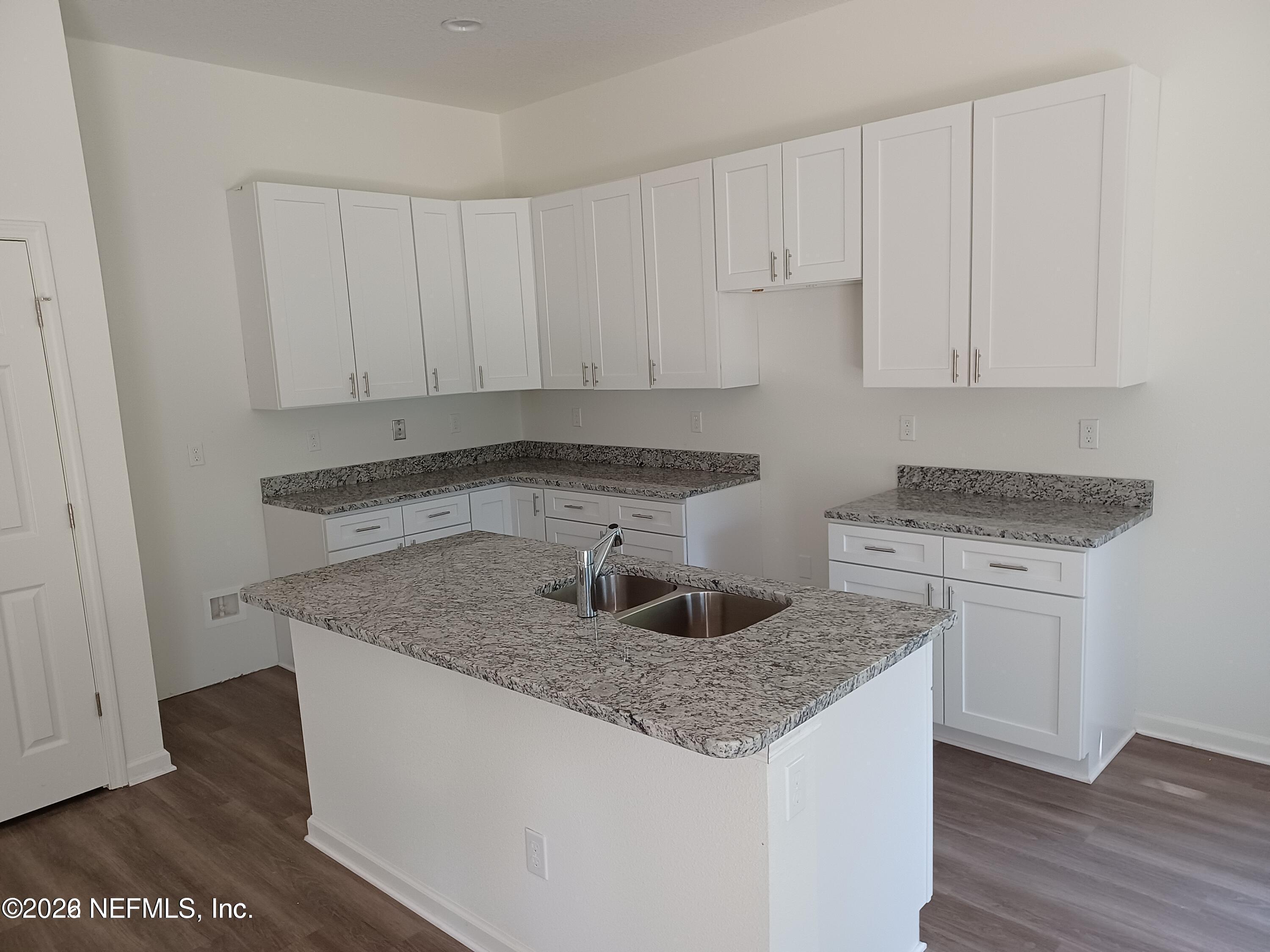 3006 Alonso Road Jacksonville, FL 32216 - Photo 5 of 16 a kitchen with granite countertop a sink and white cabinets