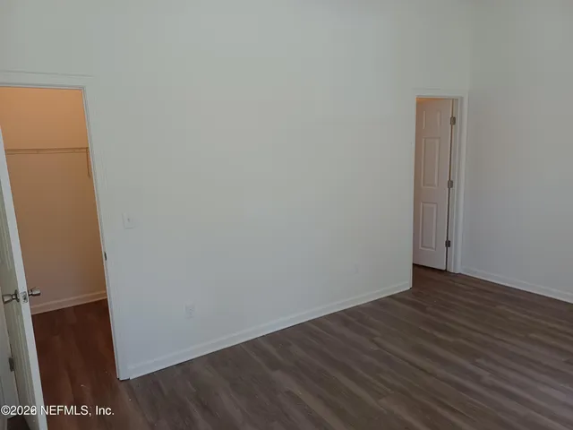 an empty room with wooden floor and cabinet