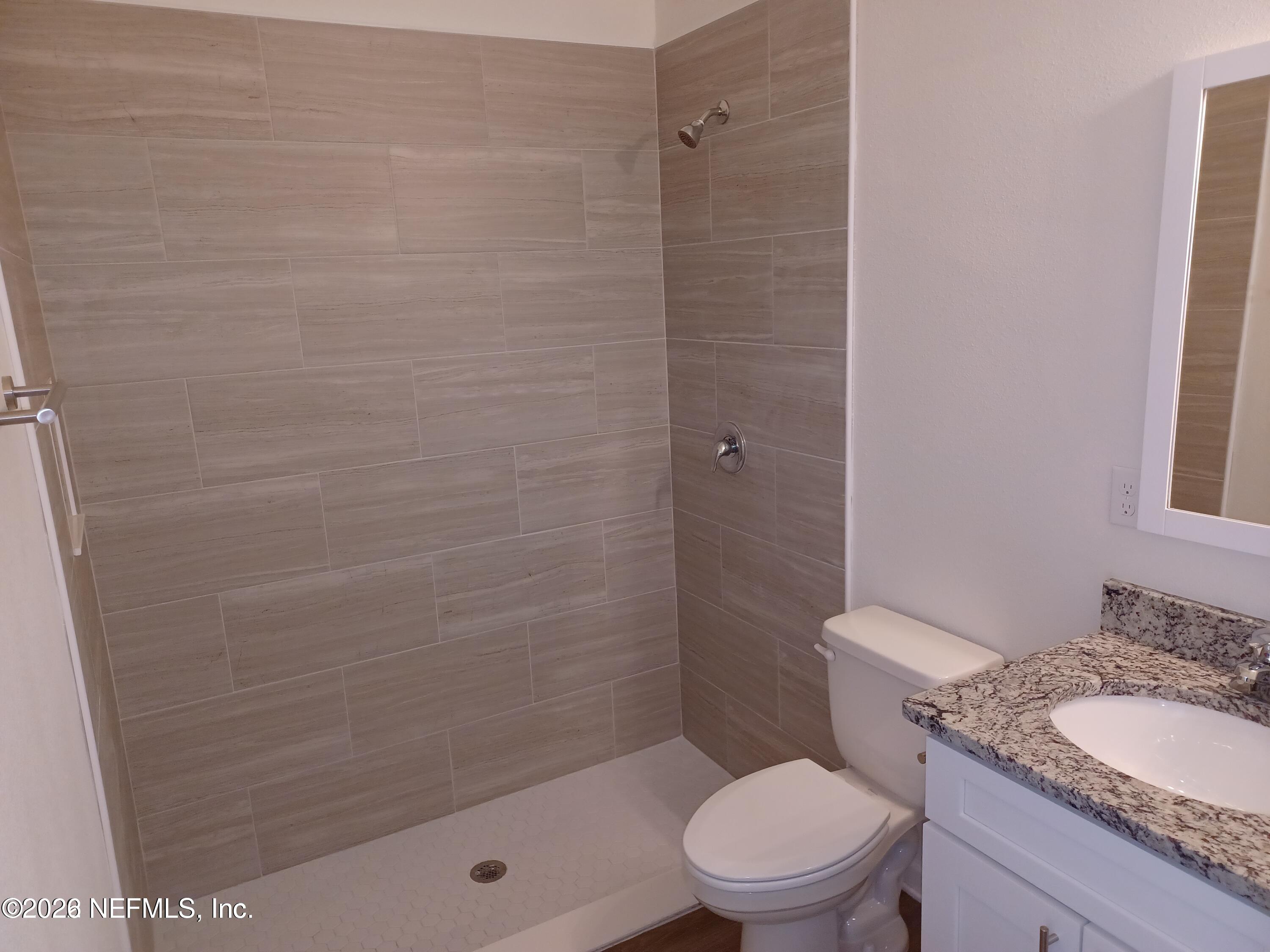 3006 Alonso Road Jacksonville, FL 32216 - Photo 8 of 16 a bathroom with a granite countertop bathtub shower sink mirror and toilet