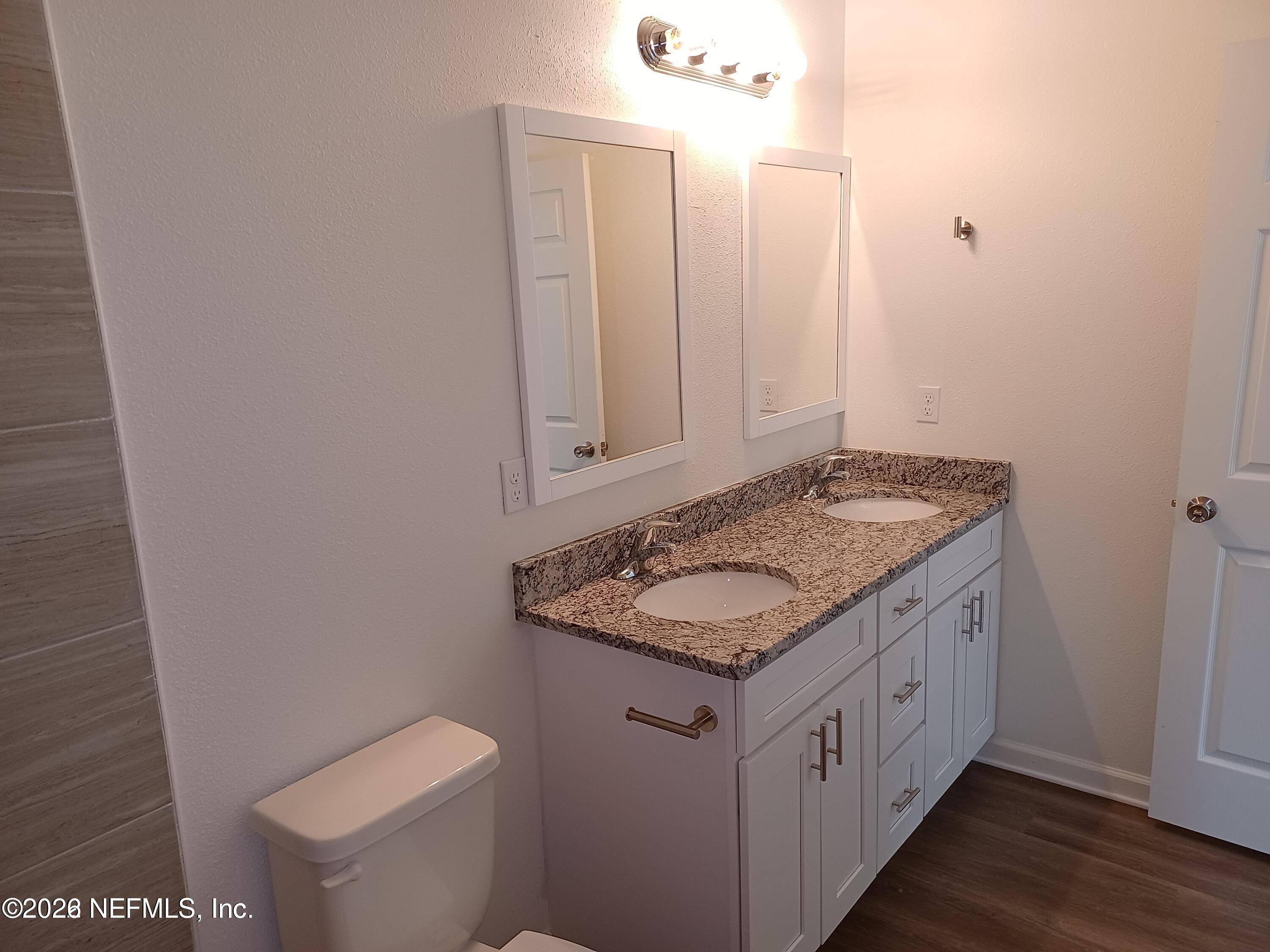 3006 Alonso Road Jacksonville, FL 32216 - Photo 9 of 16 a bathroom with a granite countertop sink and a mirror