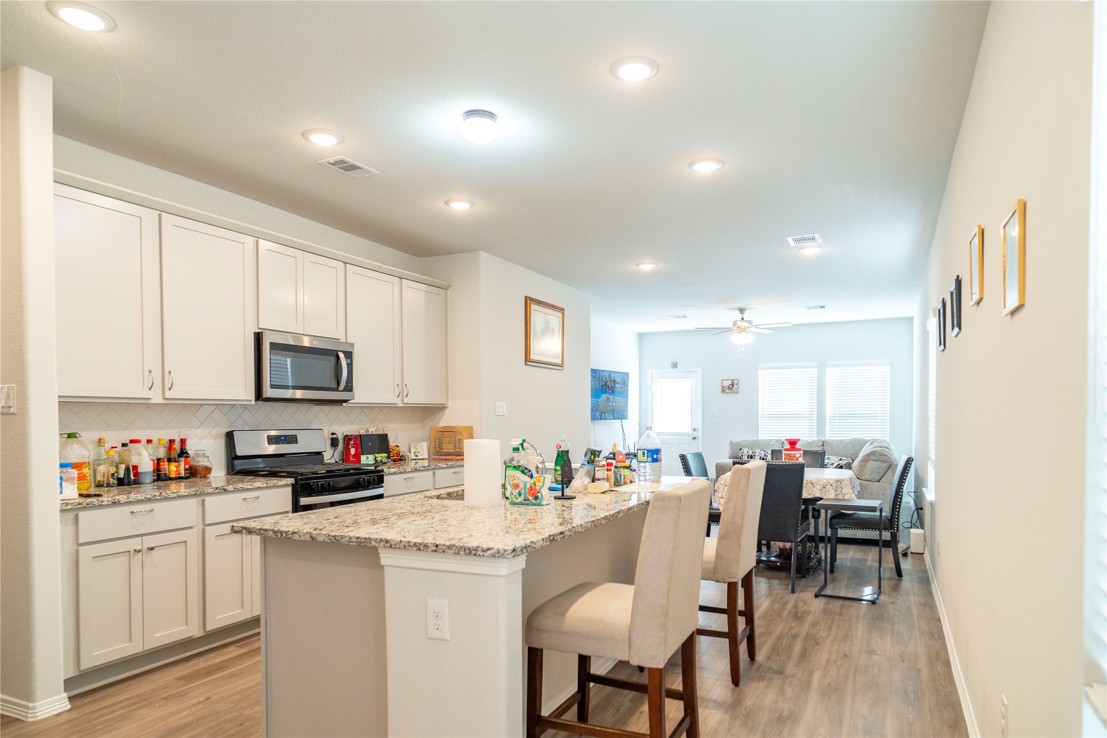 23319 Spring Genesis Lane Katy, TX 77493 - Photo 3 of 22 a kitchen with stainless steel appliances kitchen island granite countertop a refrigerator and microwave