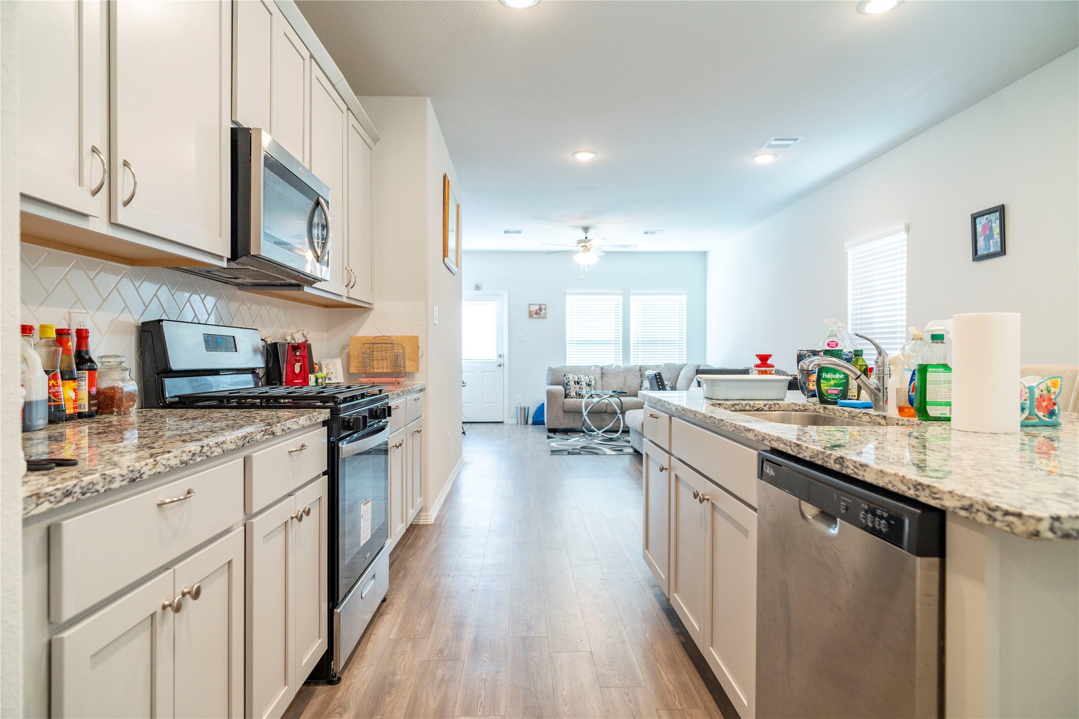 23319 Spring Genesis Lane Katy, TX 77493 - Photo 4 of 22 a kitchen with stainless steel appliances granite countertop a lot of counter space and wooden floors