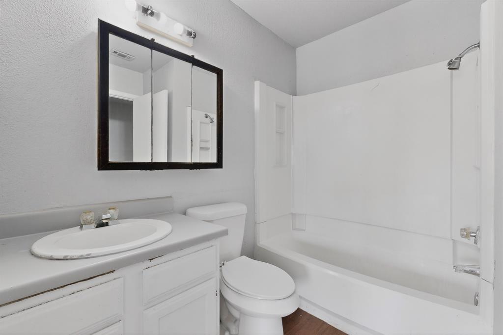 9467 Olde Towne Row Dallas, TX 75227 - Photo 22 of 26 a bathroom with a granite countertop sink toilet and a mirror