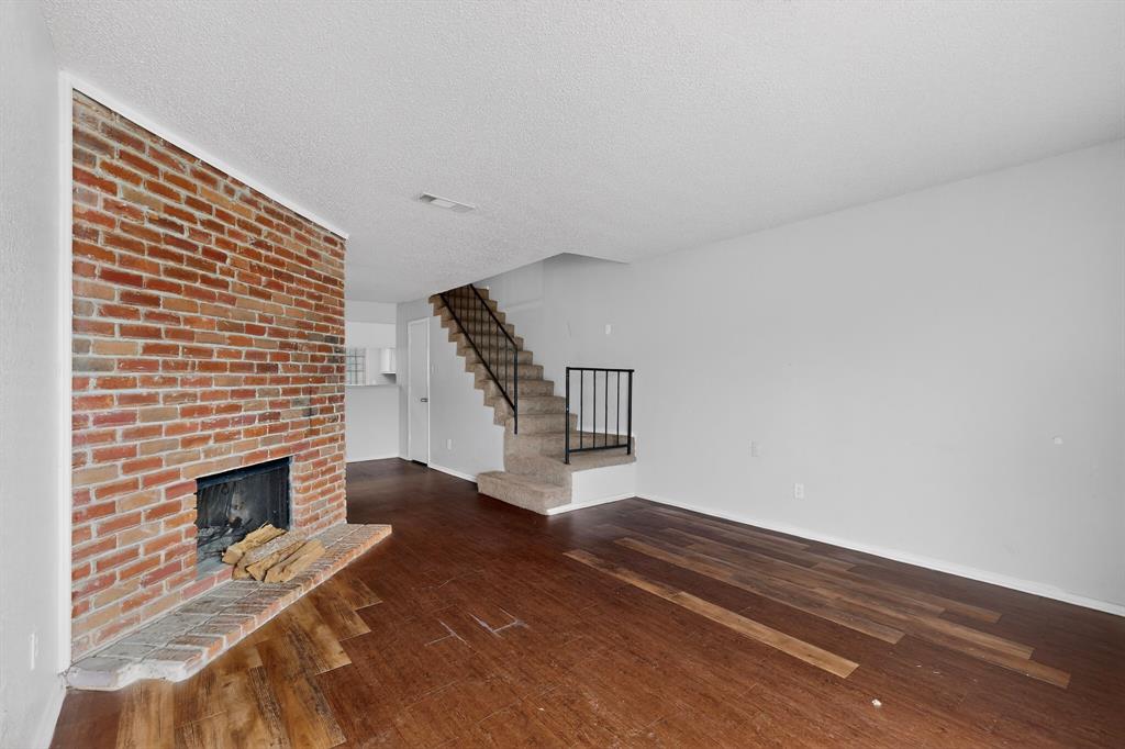 9467 Olde Towne Row Dallas, TX 75227 - Photo 5 of 26 a view of an empty room with wooden floor and a fireplace