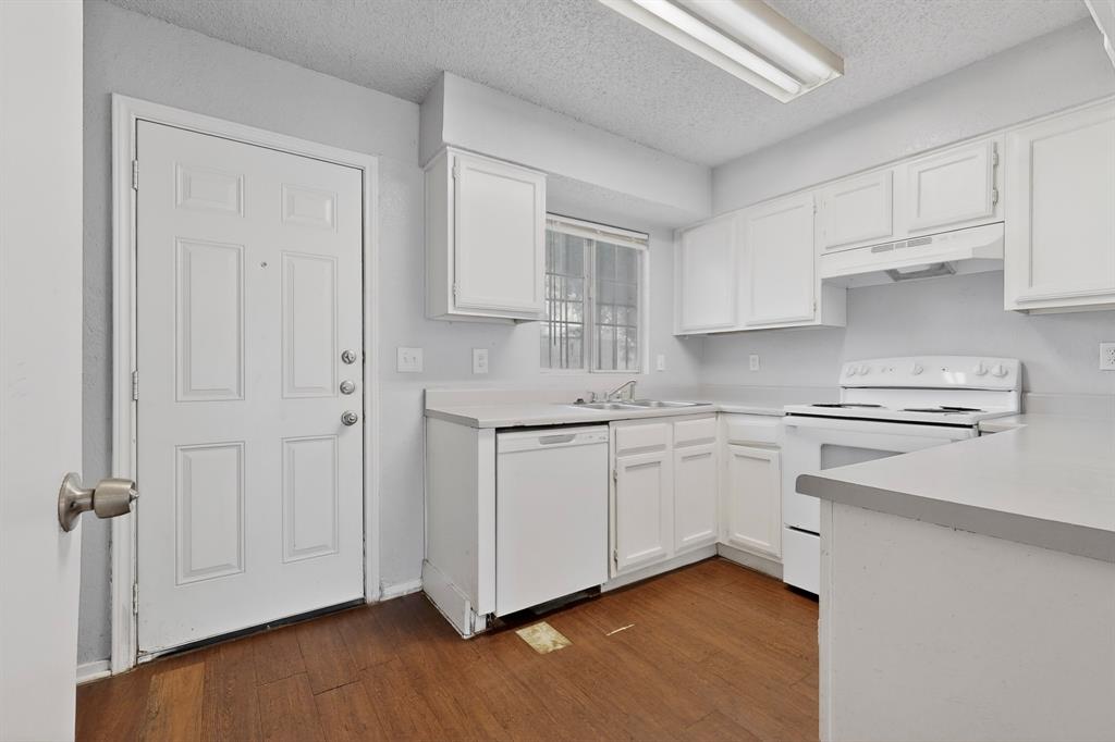 9467 Olde Towne Row Dallas, TX 75227 - Photo 7 of 26 a kitchen with white cabinets and white appliances