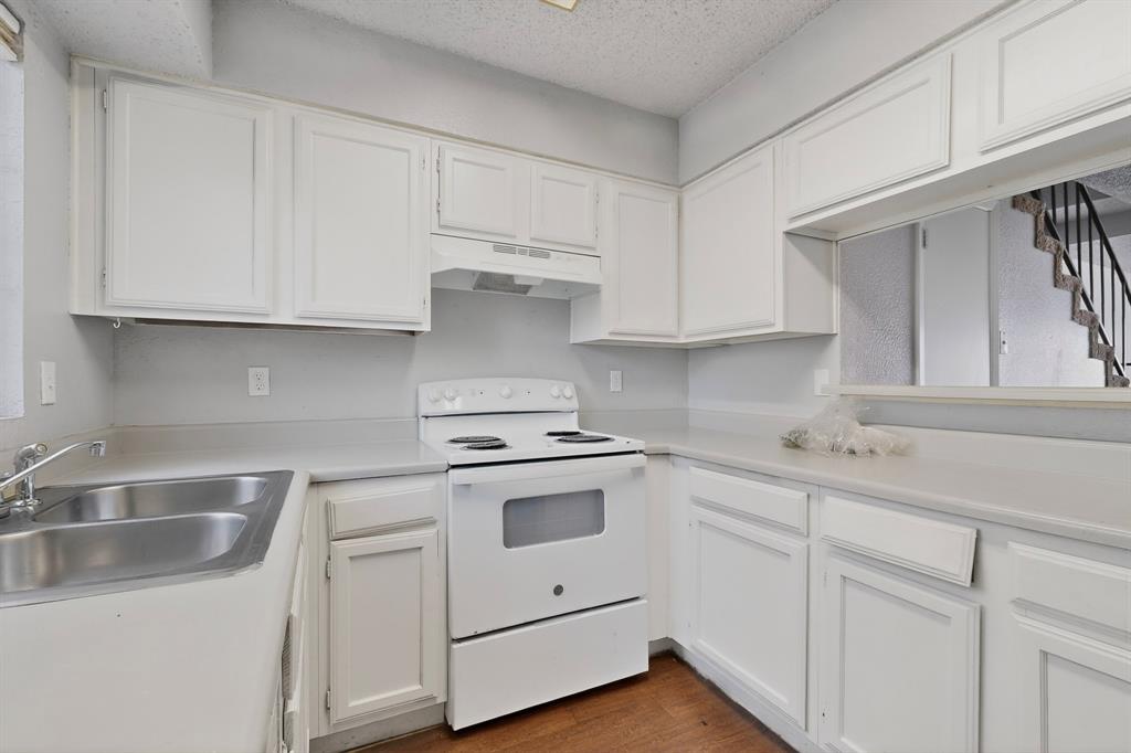 9467 Olde Towne Row Dallas, TX 75227 - Photo 9 of 26 a kitchen with white cabinets and white appliances