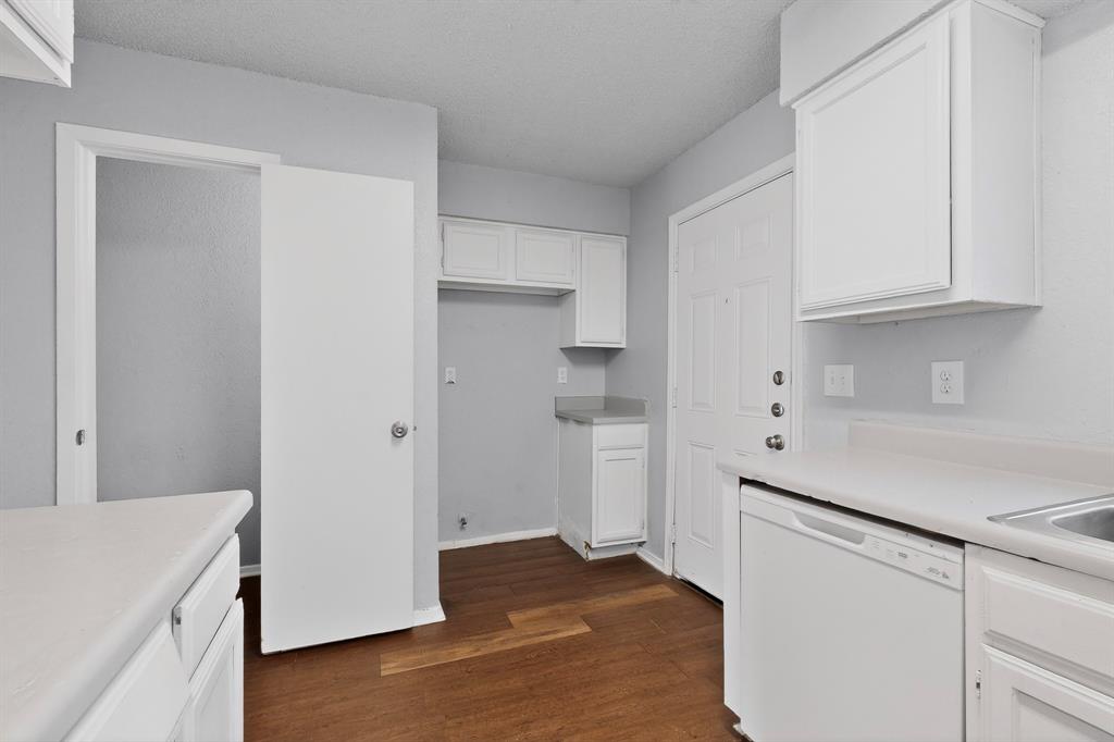 9467 Olde Towne Row Dallas, TX 75227 - Photo 10 of 26 a kitchen with a refrigerator and white cabinets