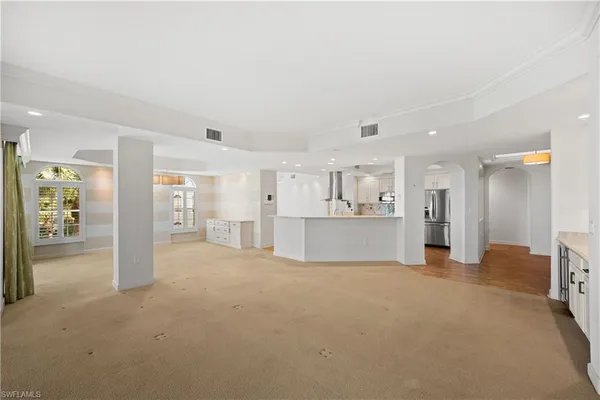 a view of a livingroom with kitchen and a window