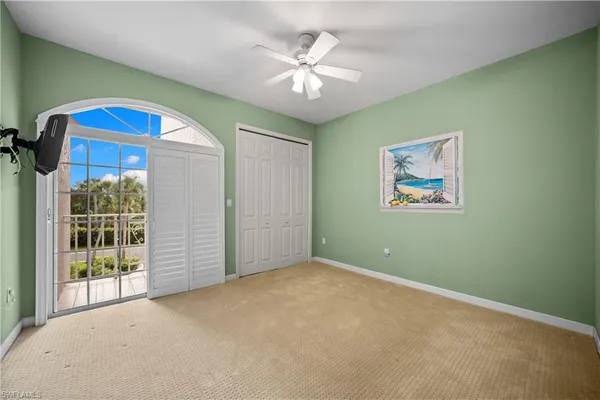 an empty room with windows and fan