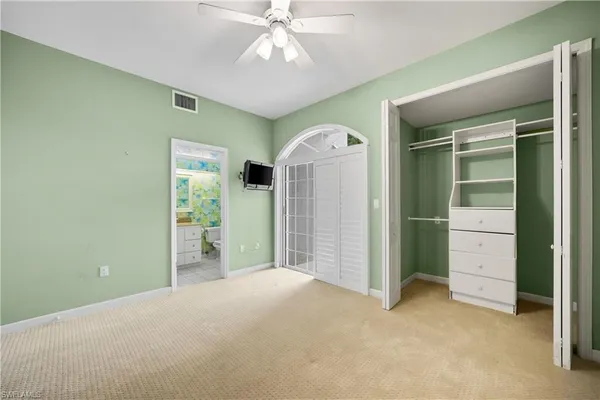 an empty room with closet and windows