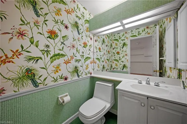 a bathroom with a toilet sink and mirror