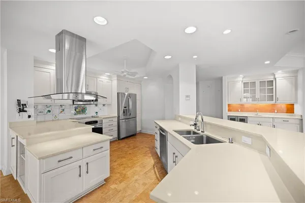 a kitchen with stainless steel appliances kitchen island granite countertop a sink and a refrigerator