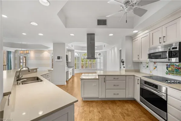 a large kitchen with stainless steel appliances lots of counter space and wooden floor