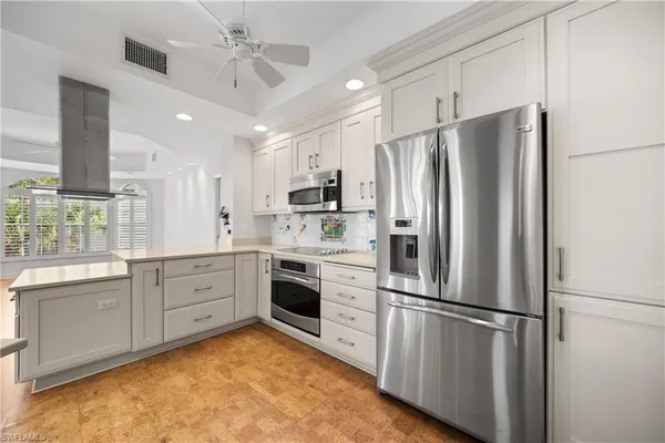 a kitchen with stainless steel appliances a refrigerator sink and microwave