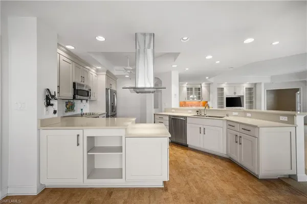a kitchen with stainless steel appliances kitchen island granite countertop a sink and white cabinets