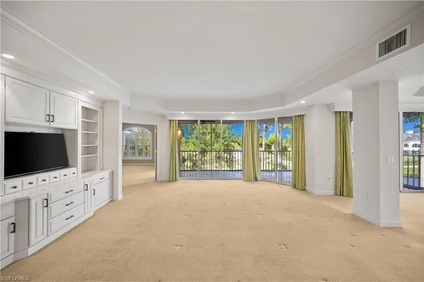 a view of an empty room with window and cabinet