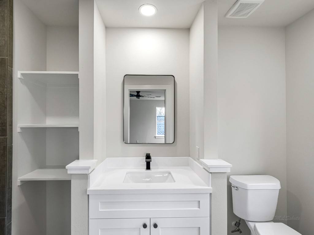 1006 4th Street Hempstead, TX 77445 - Photo 24 of 29 a bathroom with a toilet sink vanity and mirror