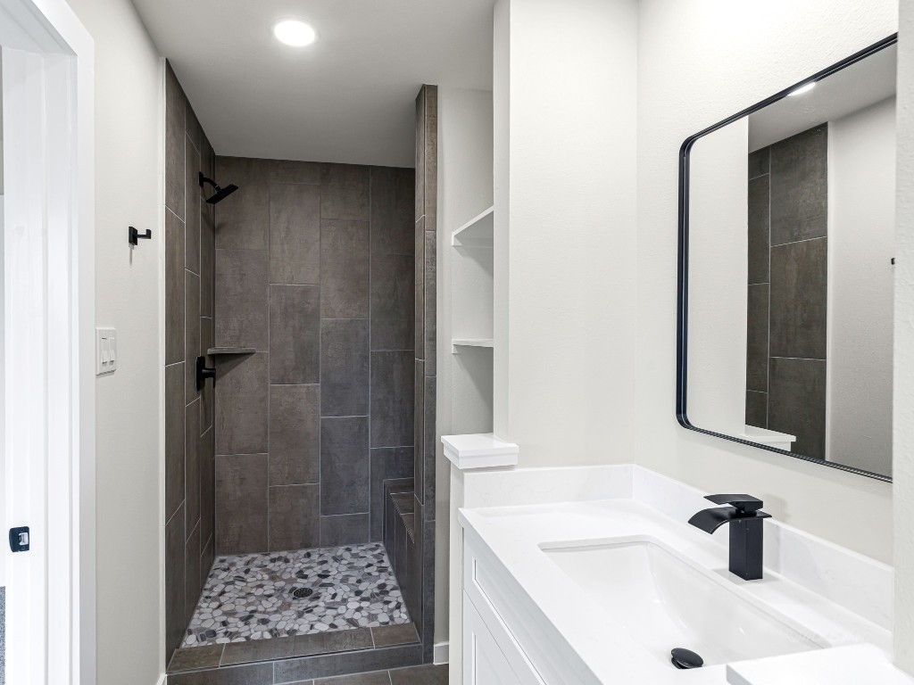 1006 4th Street Hempstead, TX 77445 - Photo 25 of 29 a bathroom with a sink a shower and a mirror