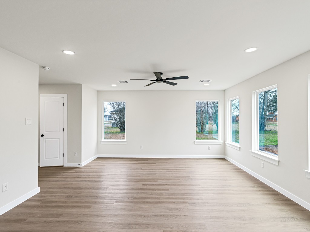 1006 4th Street Hempstead, TX 77445 - Photo 9 of 29 a view of an empty room with wooden floor and a window