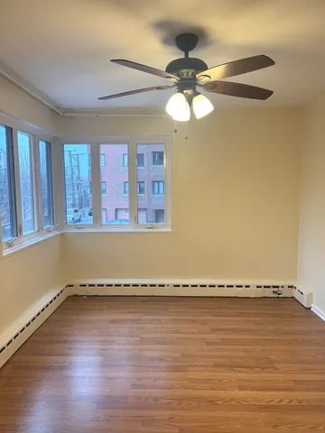 a view of a room with wooden floor and window