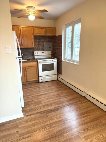 a kitchen with wooden floors and white appliances