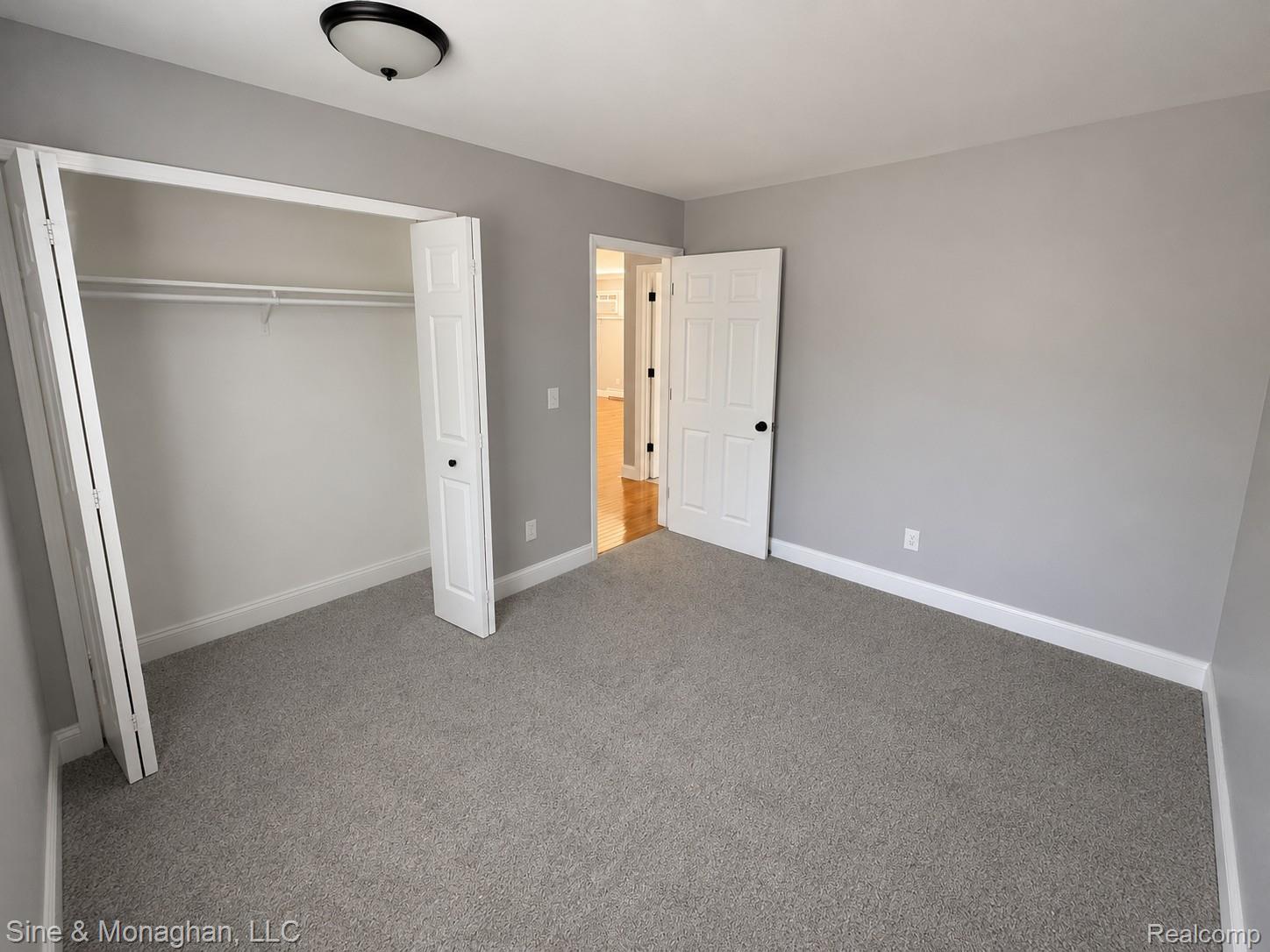 433 Miller Avenue, Unit 203 Rochester, MI 48307 - Photo 6 of 12 Bedroom featuring gray carpeting, light gray walls, and white trim
