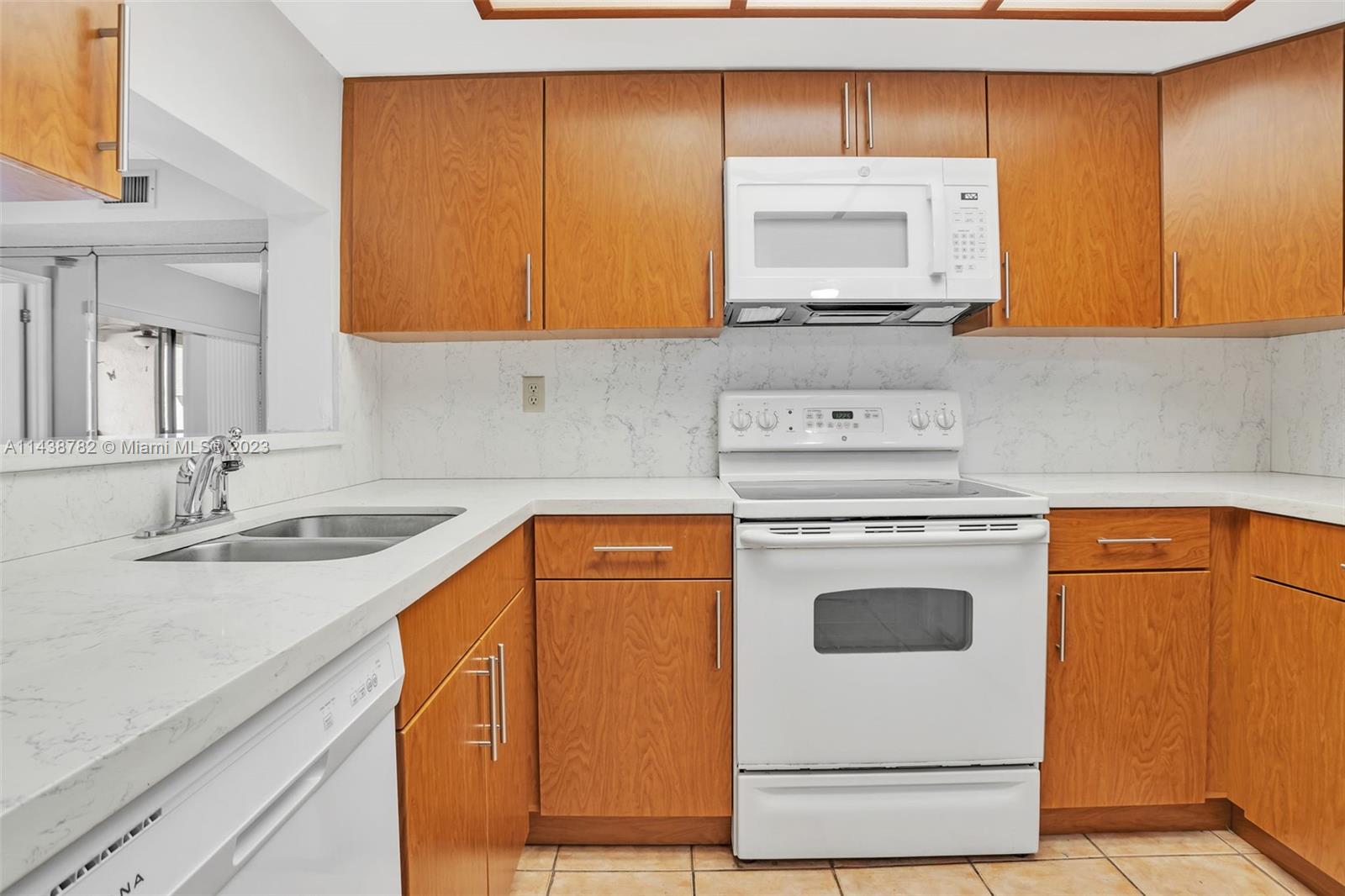 9140 Southwest 123rd Court, Unit 210Q Miami, FL 33186 - Photo 9 of 26 a kitchen with stainless steel appliances granite countertop a sink stove and refrigerator