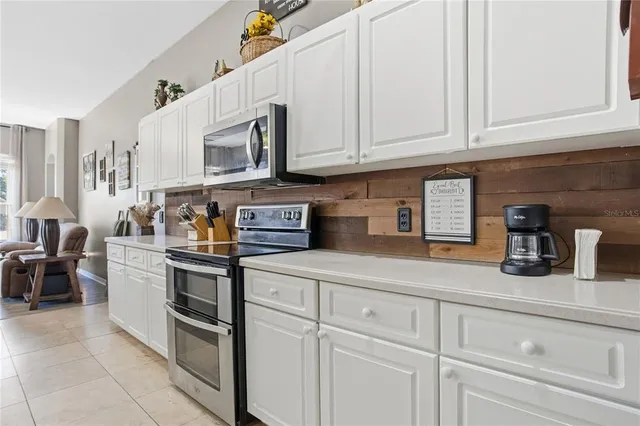 a kitchen with stainless steel appliances granite countertop white cabinets a sink and dishwasher