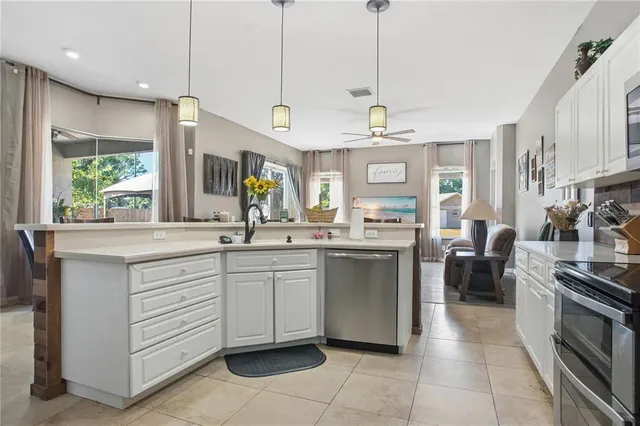a open kitchen with stainless steel appliances granite countertop a sink and a large window