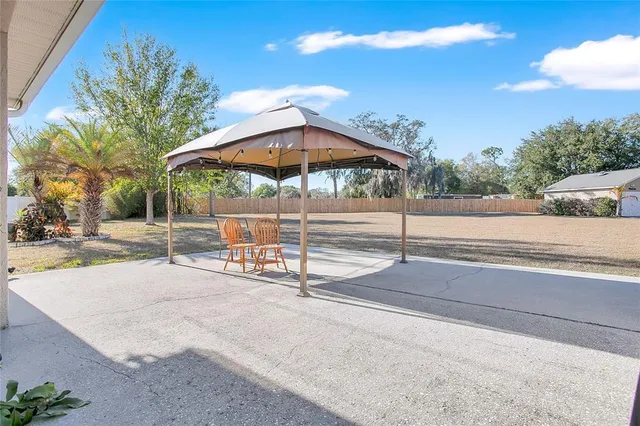 a view of a patio with a table and chairs under an umbrella