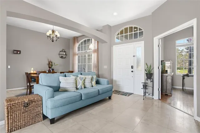 a living room with furniture ceiling fan and a window