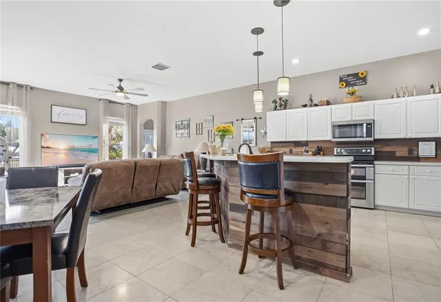 a kitchen with kitchen island a dining table and chairs
