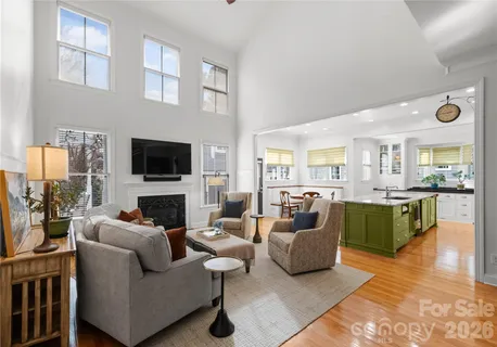 a kitchen with stainless steel appliances granite countertop a stove top oven a sink a dining table and chairs