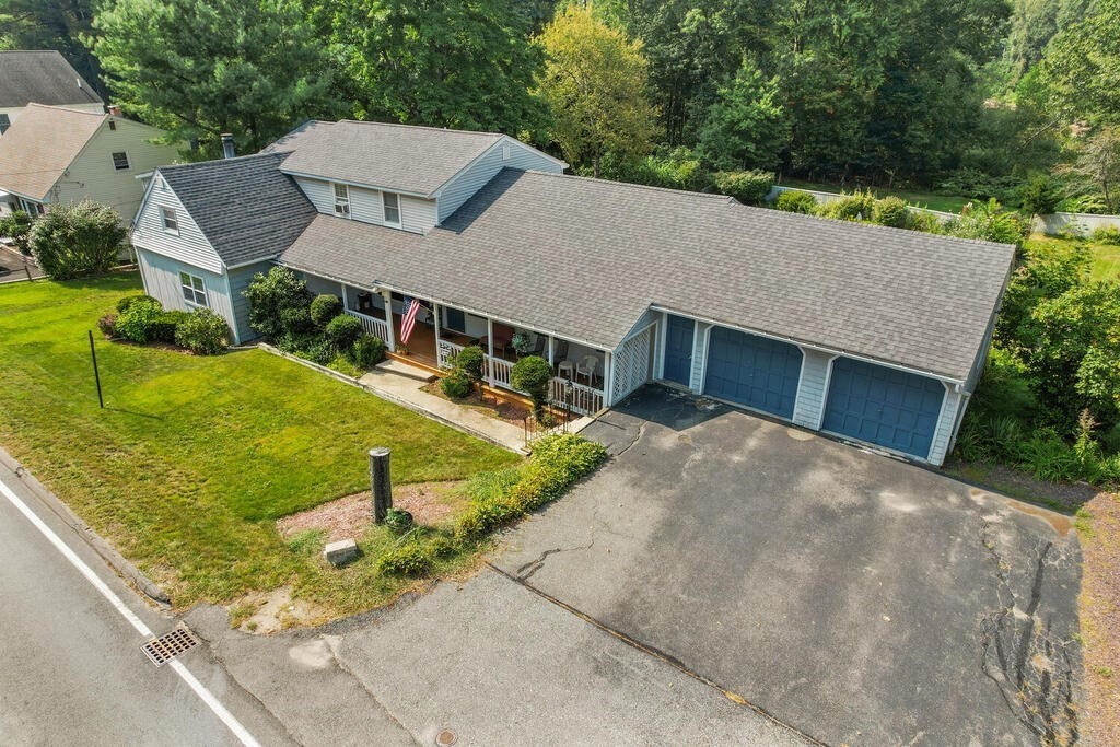 a aerial view of a house with a yard and large tree