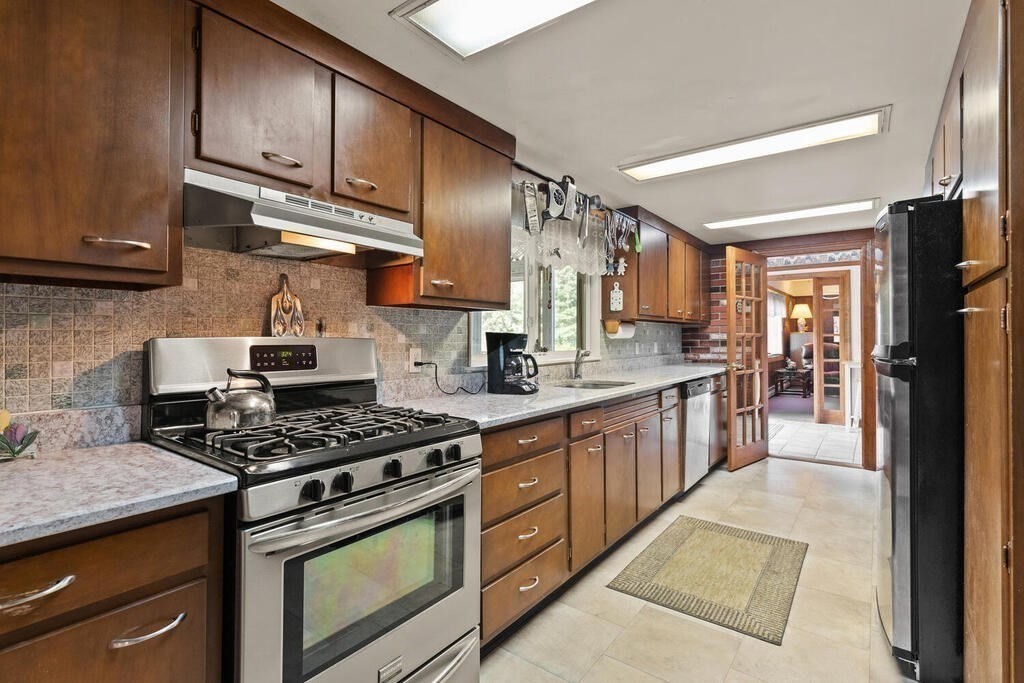 306 Andover Road Billerica, MA 01821 - Photo 14 of 42 a kitchen with stainless steel appliances granite countertop a stove a sink and a refrigerator