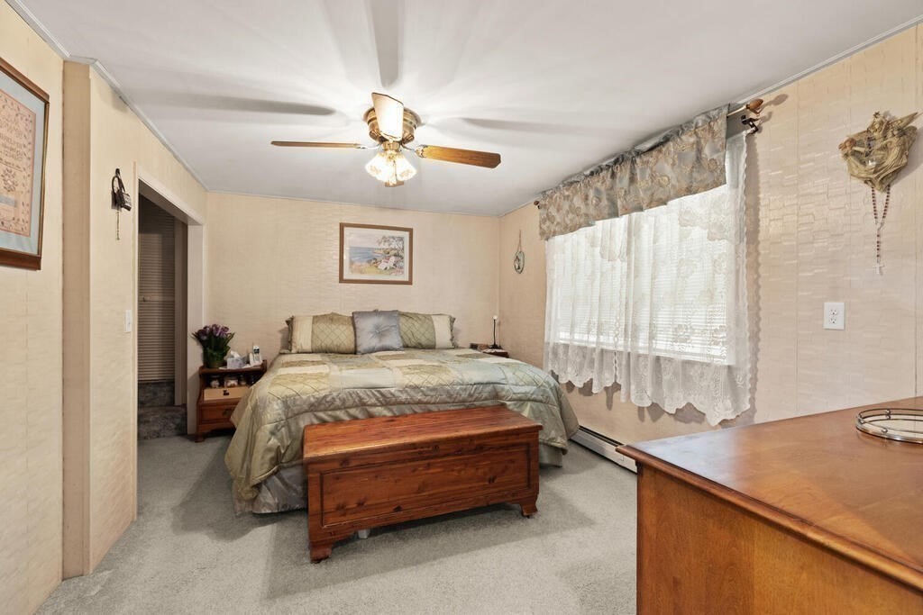 306 Andover Road Billerica, MA 01821 - Photo 15 of 42 a spacious bedroom with a bed and a chandelier
