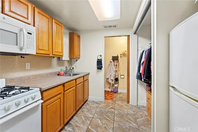 a kitchen with stainless steel appliances granite countertop a stove a sink and a refrigerator