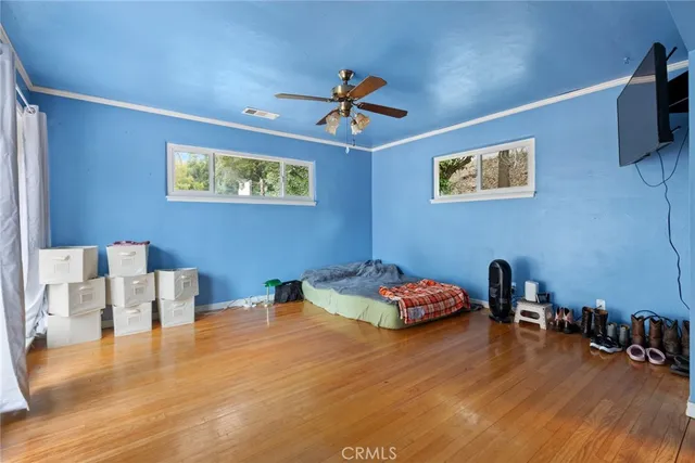 a bedroom with furniture and wooden floor