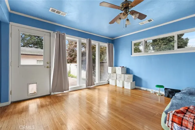 a view of an empty room with a window and wooden floor