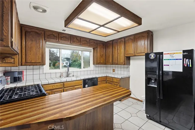 a kitchen with stainless steel appliances granite countertop a refrigerator and a stove top oven