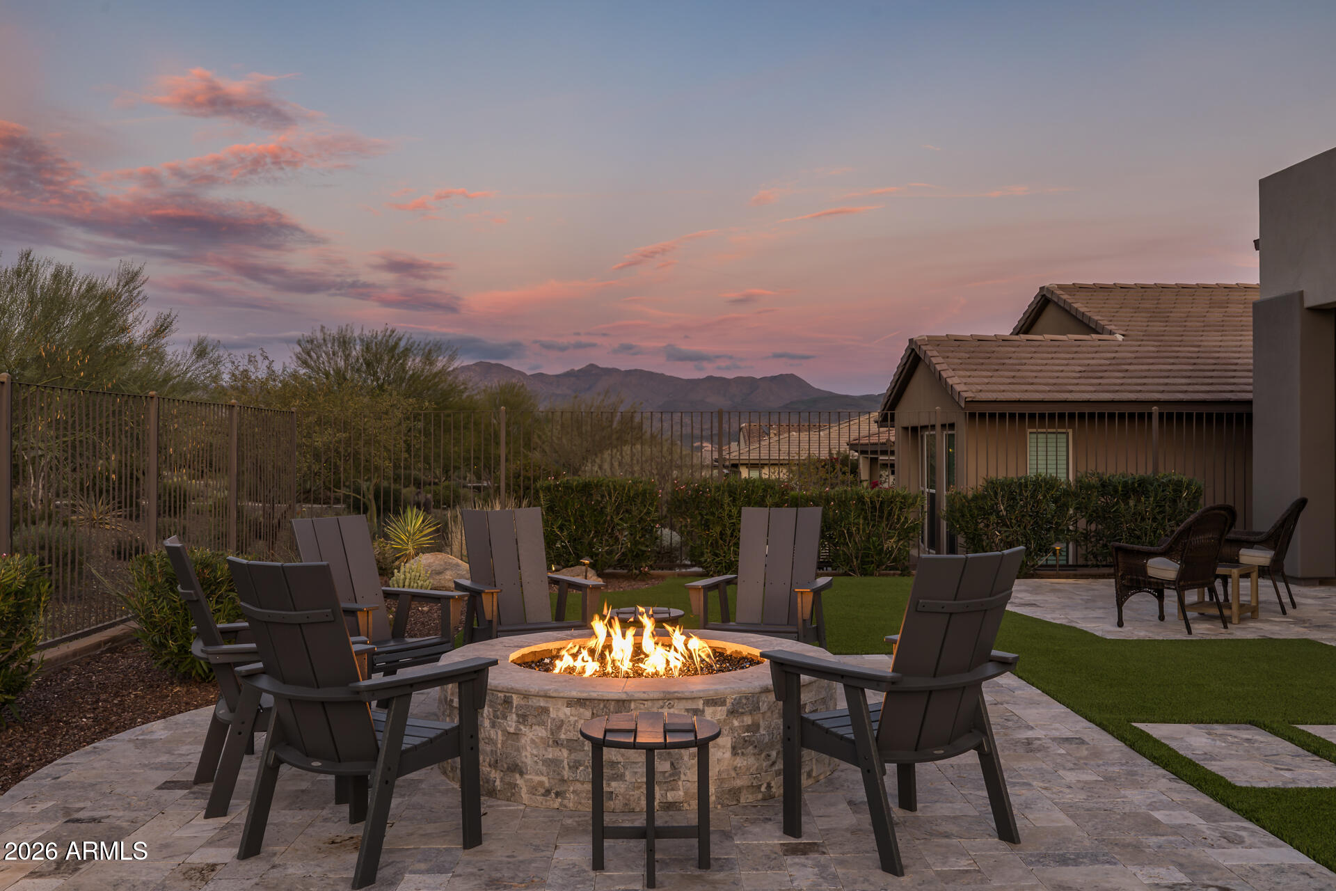 a patio with tables and chairs and a fire pit