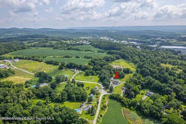 an aerial view of residential houses with outdoor space and trees