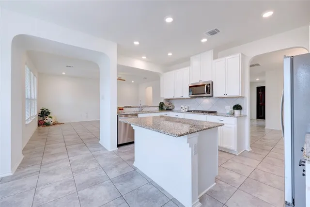 a kitchen with stainless steel appliances a refrigerator sink and microwave