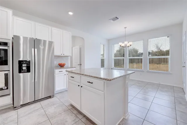 a view of an empty room with a window and chandelier