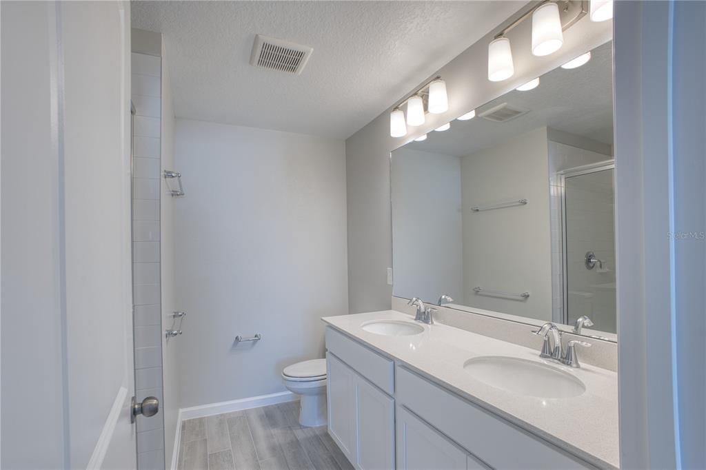 4188 Campsite Loop Orlando, FL 32824 - Photo 20 of 38 a bathroom with a toilet a sink and mirror