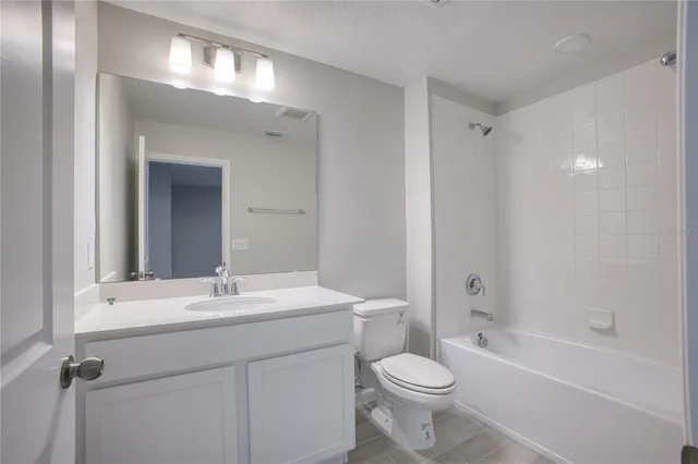 a bathroom with a sink a toilet a mirror and shower