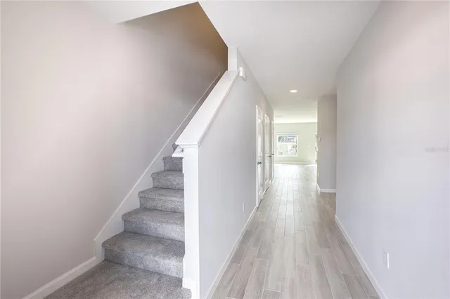 a view of a hallway with wooden floor and staircase