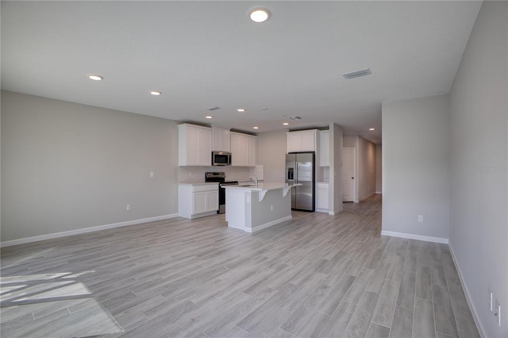 4188 Campsite Loop Orlando, FL 32824 - Photo 6 of 38 a view of kitchen with kitchen island wooden floors and stainless steel appliances